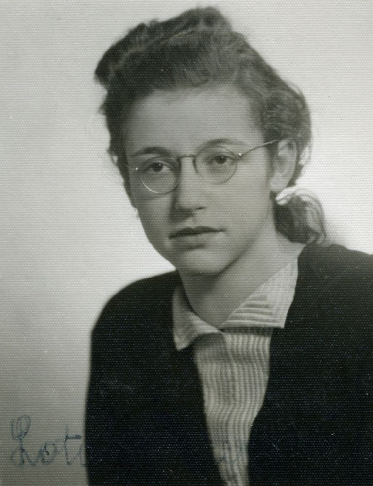 Black and white portrait of a young person wearing glasses, and a dark blazer.