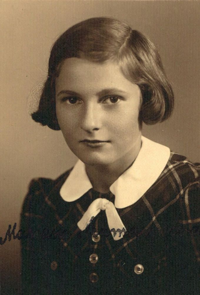 Vintage portrait of a young girl wearing a plaid dress with a collared shirt and a bow tie