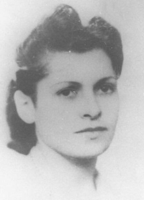 Black and white portrait of a young person with a serious expression, featuring short, styled hair.