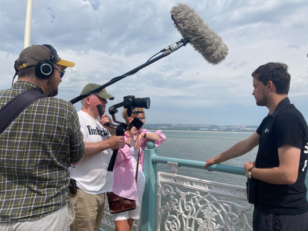 Gethin talking to camera with the coastline behind.