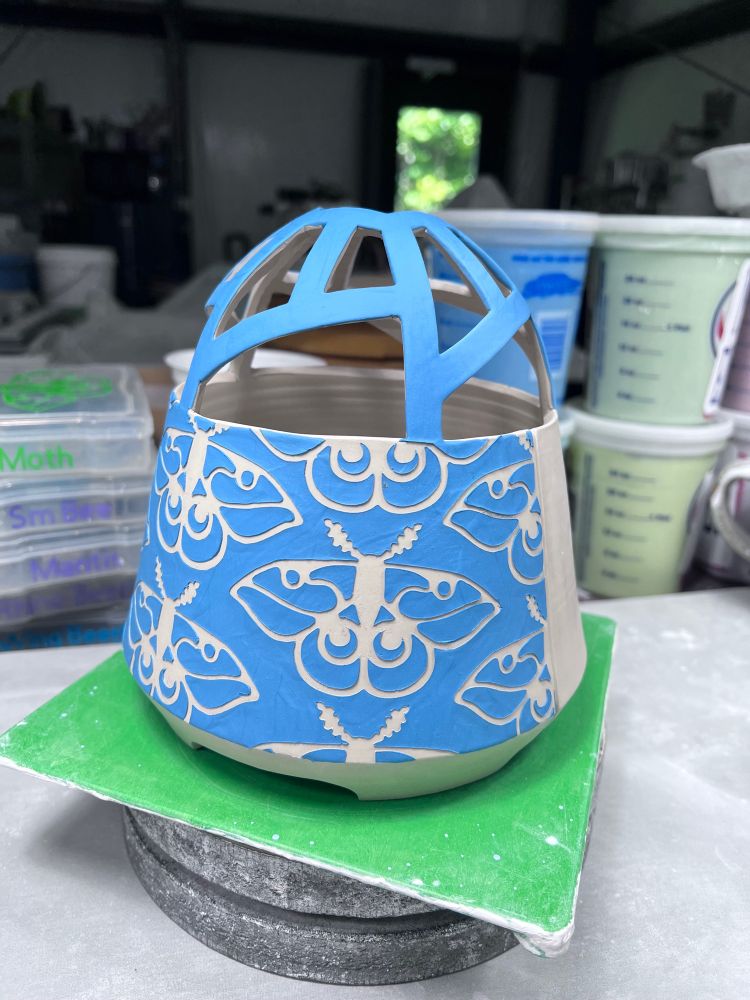 Ceramic flower dome with a peacock blue moth design