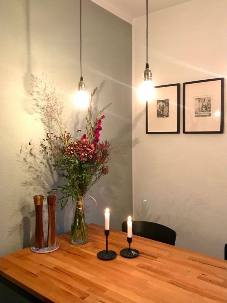 Zimmer mit herbstlichem Blumenstrauß und Kerzen auf dem Tisch