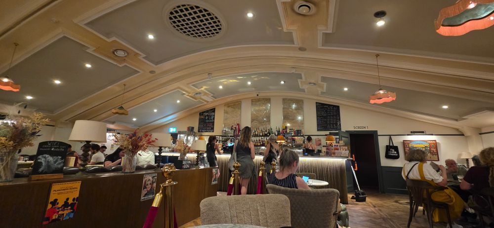 Picture of the inside of the lobby of the Castle Cinema in Clapton, Hackney. It is an art deco design with curved ceiling, and a bar.