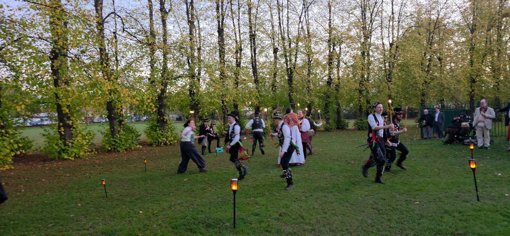 Morris dancing at sunset surrounded by lights