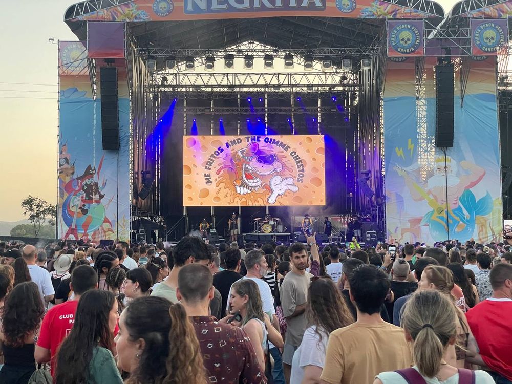 Concierto en el que se ve al grupo Me fritos. Está atardeciendo