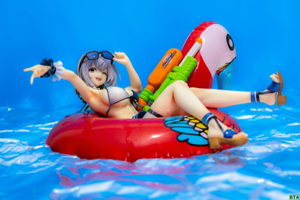 A photo if the Hololive - Shirogane Noel - 1/7 - Swimsuit Ver. figure by Good Smile Company. 

Noel is sitting in a big bright red flamingo floaty drifting in the water, next to her is a classic Super Soaker water gun. 
