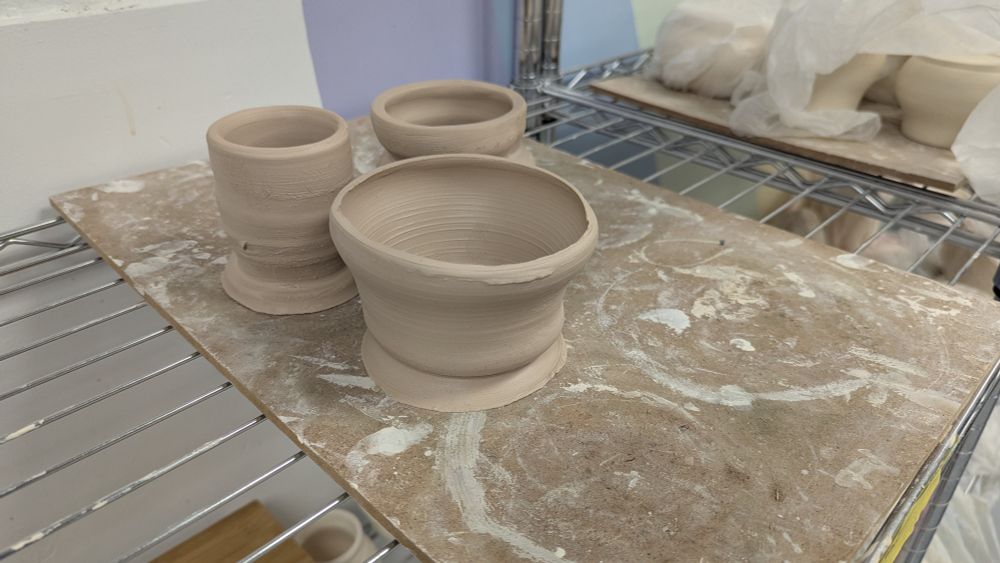 Messy pottery sitting on a wooden board