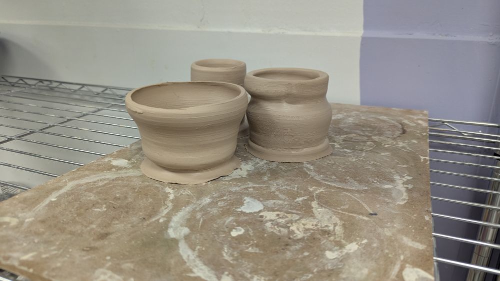 Messy pottery sitting on a wooden board