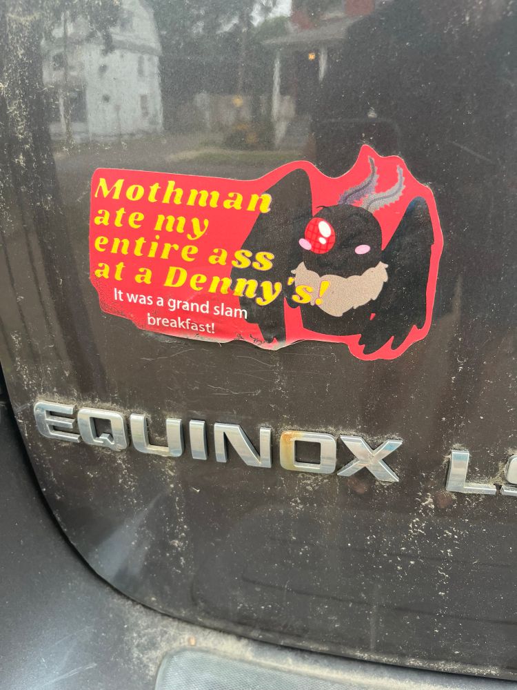 A bumper sticker on an Equinox. A cartoon moth man next to the words “Mothman ate my entire ass at a Denny’s! It was a grand slam breakfast!”