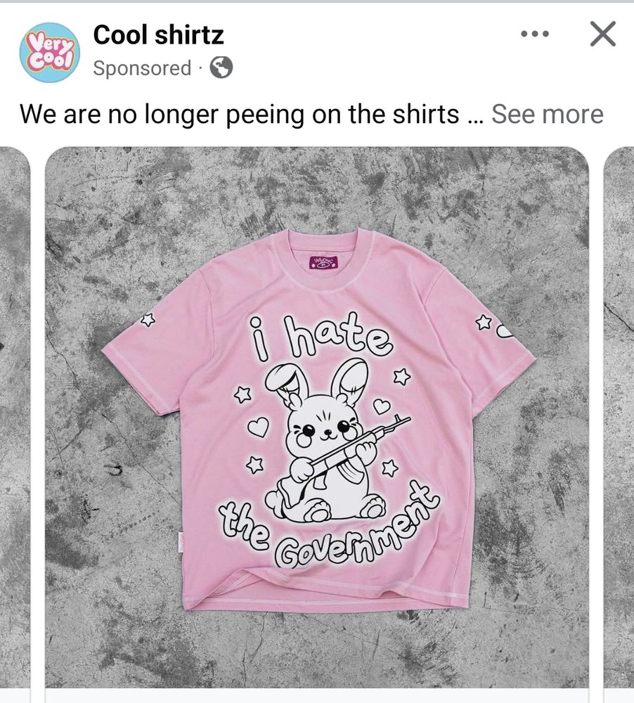 Screenshot of an advert on Facebook. The brand is Cool Shirtz. The description say: "We are no longer peeing on the shirts..." and is cut off there. The shirt on display is a pale pink tshirt with a white toy rabbit graphic on the front, holding a rifle. It says "I hate the government" on it.