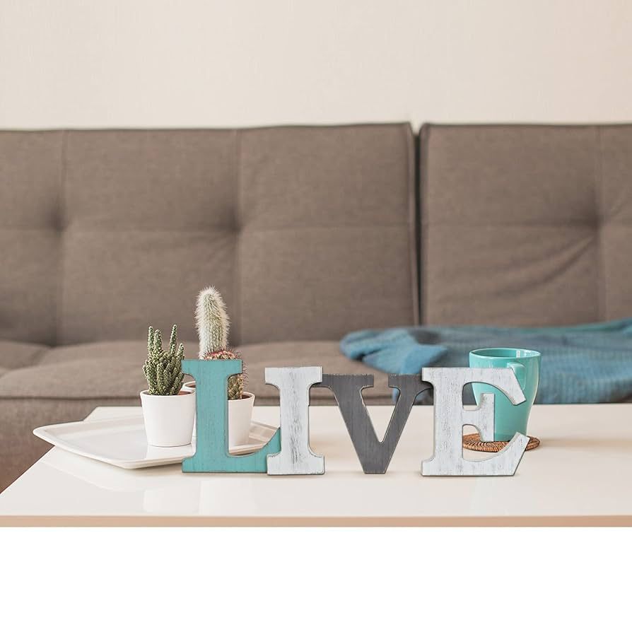 Decorative letters L, I , V, and E spelling LIVE on a table in front of a couch