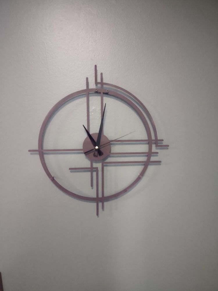 An art-deco-ish circular clock hanging on a wall.