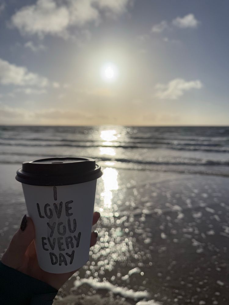 Take away coffee cup in front of the sea