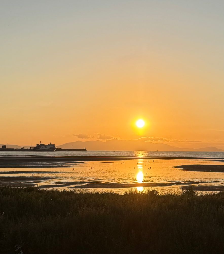 Sunset over Arran from Barassie and Troon Harbour, with Glen Sannox in port.