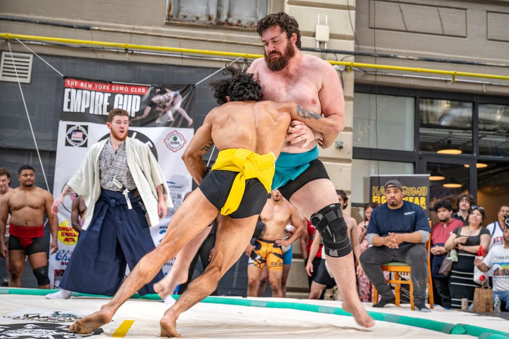 Daniel Douglas, right, and Angelo Lizardi, left, face off during an open-weight division match. Lizardi, who is much smaller than Douglas, slammed into his chest as they fought for dominance at an amateur sumo tournament.