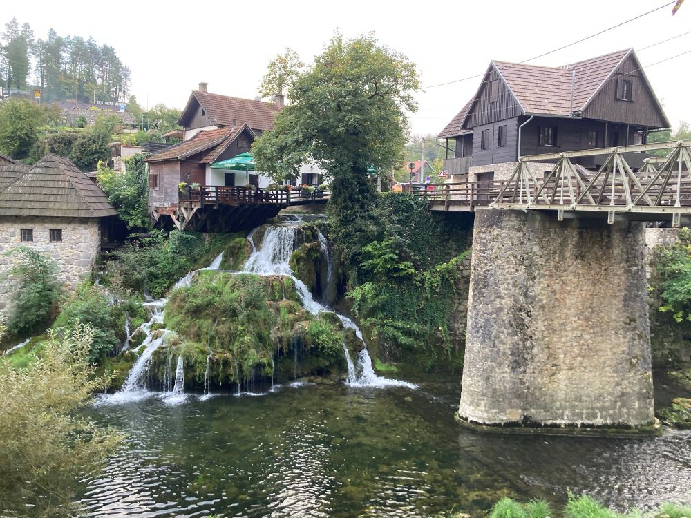 Small waterfall next to an old bridge into town