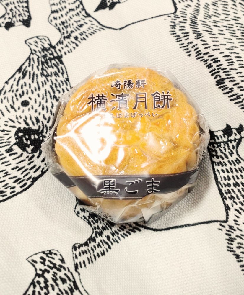 写真。崎陽軒の月餅黒ごまあん。包装フィルムに光が反射している。
