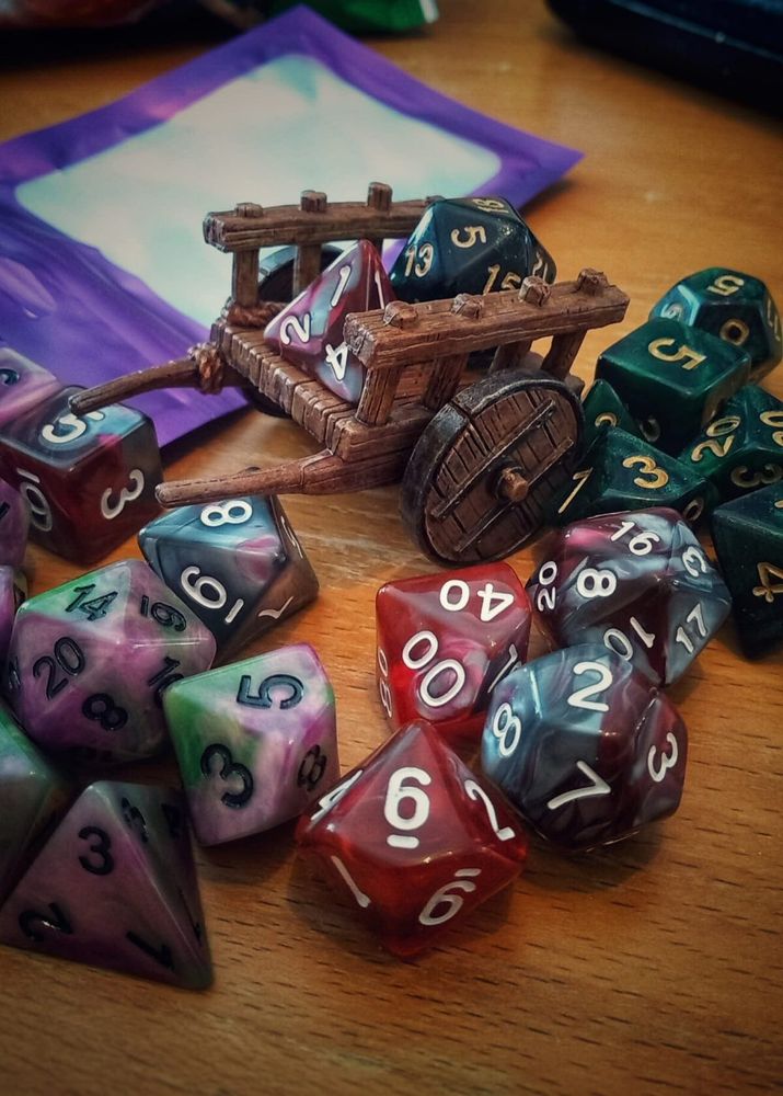 A selection of dice from gametee.co.uk displayed on a miniature cart.