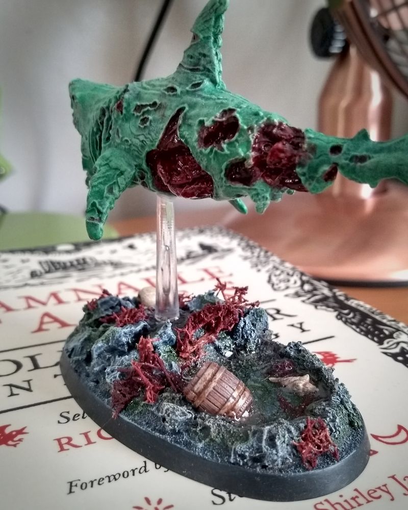 Zombie shark miniature from Reaper, on a rock pool themed base.