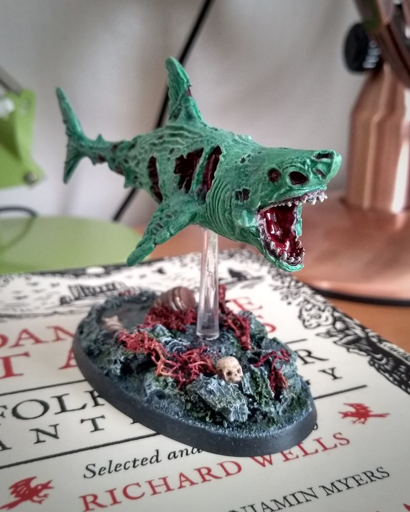 Zombie shark miniature from Reaper, on a rock pool themed base.