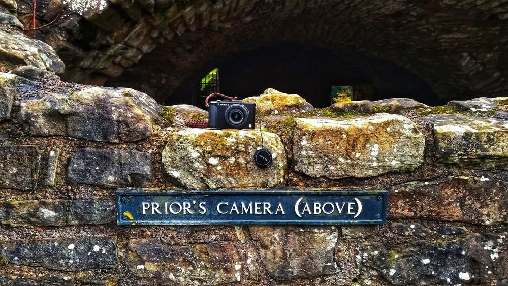 A small compact camera sits above a sign at the ruins of Finchale Priory, County Durham.