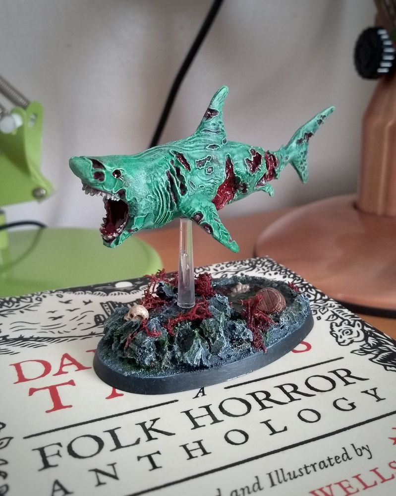 Zombie shark miniature from Reaper, on a rock pool themed base.