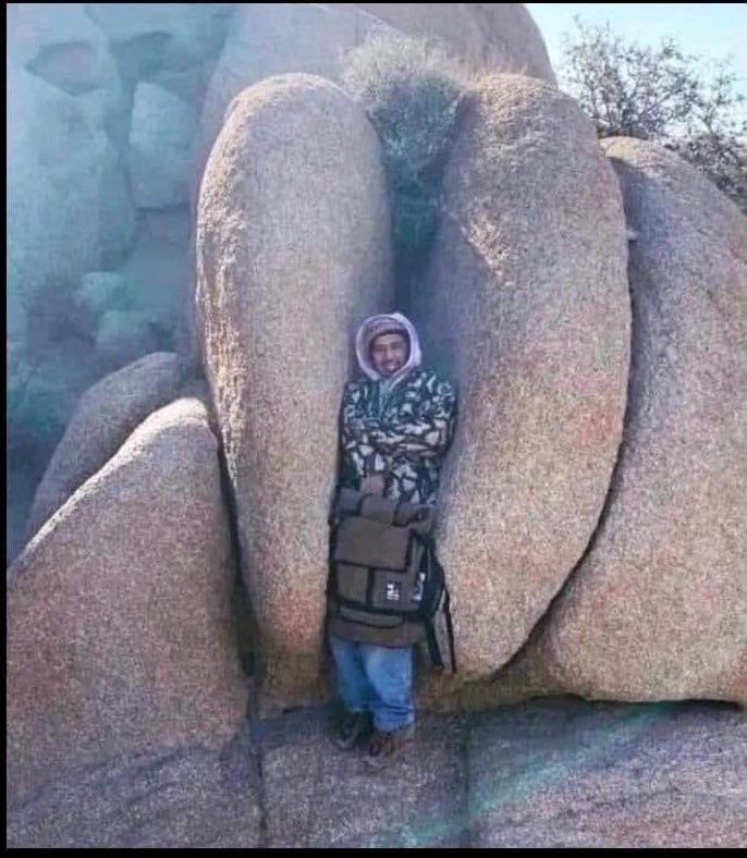 Man standing inside of a rock shaped like a moose knuckle 
