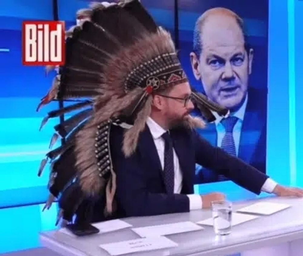 Das Bild zeig den Rassisten und stellvertretenden Bild Chefredakteur Paul Ronzheimer mit dem klischeehaften Kopfschmuck amerikanischer Ureinwohner.