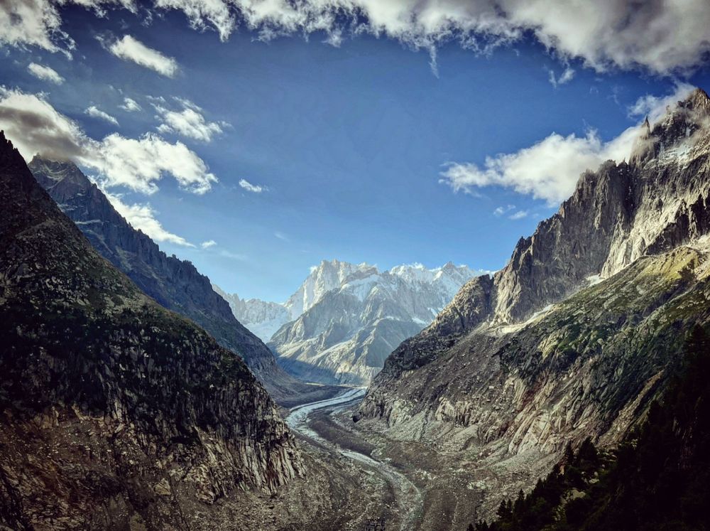 A view of the Mer de Glace glacier in the French alps, taken from the Montenvers train station. The river of ice - half covered in dirt - winds toward the camera, with the Grande Jorass peaks rising majestically in the background. Alpine splendour!