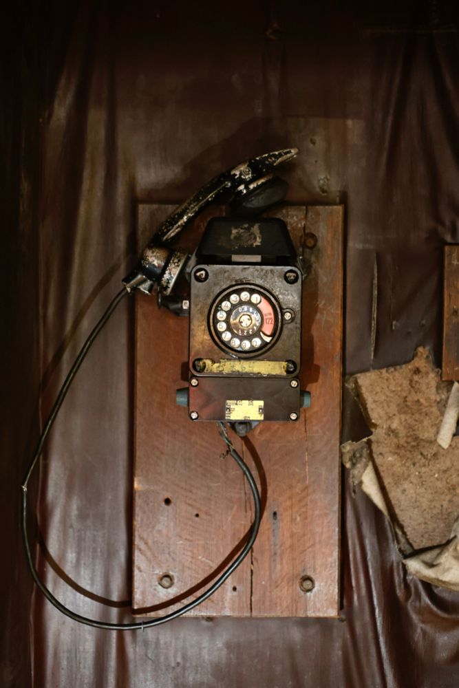 Ein antikes schwarzes Telefon hängt an der Wand