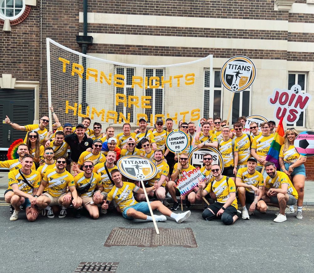 A photo of around 40 London Titans FC players in front of a goal net with the slogan 'Trans Rights Are Human Rights' at the Pride in London parade
