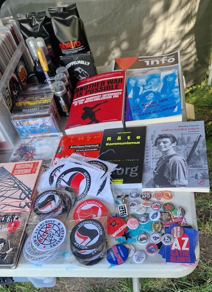Book table with a few antifascist books, pins, patches.