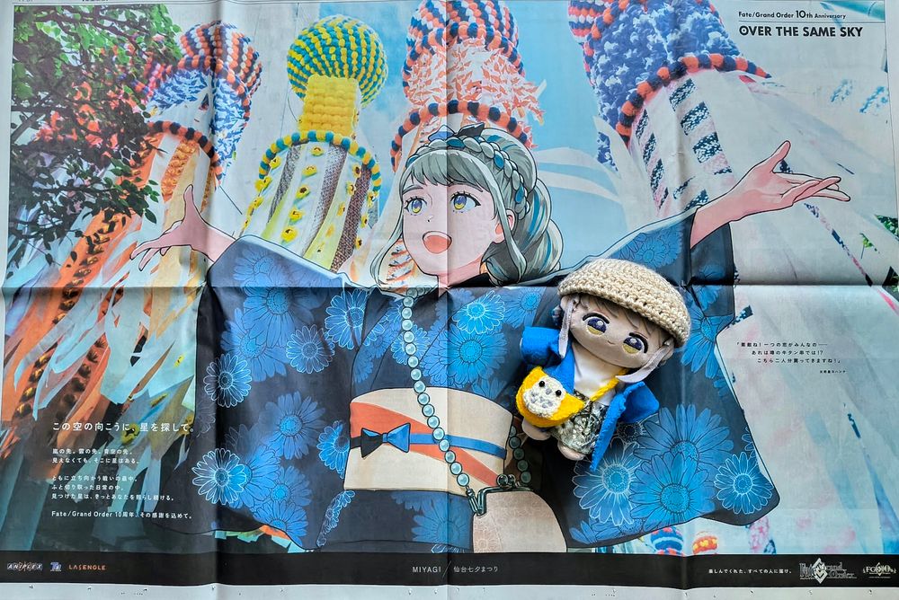 新聞の全面広告。両手を広げて上を見上げている、デイジー柄の浴衣を着たヨハンナ。背後には七夕飾りが並んでいる。中央右下にぬいぐるみが置かれている。