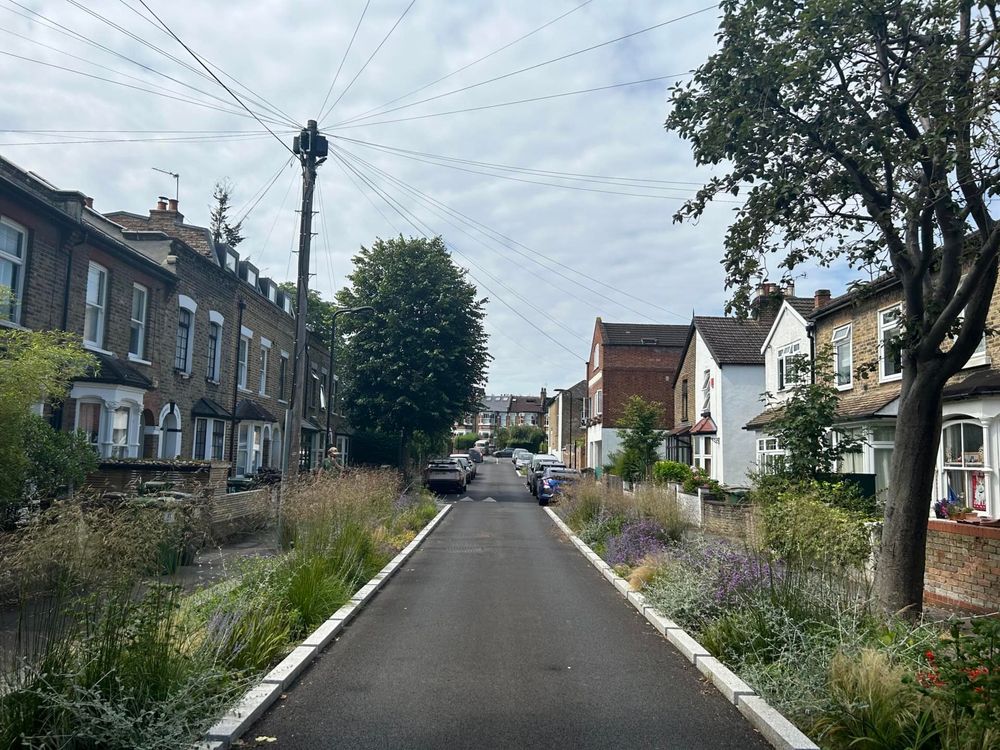 A terraced street with parking removed and rain gardens installed both sides