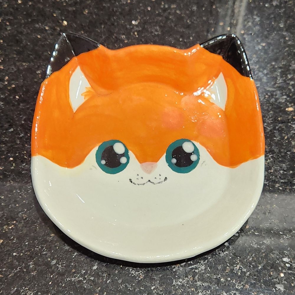 Handmade ceramic plate, shaped like a cat, painted to look like a fursona (@Kat_aclysm)