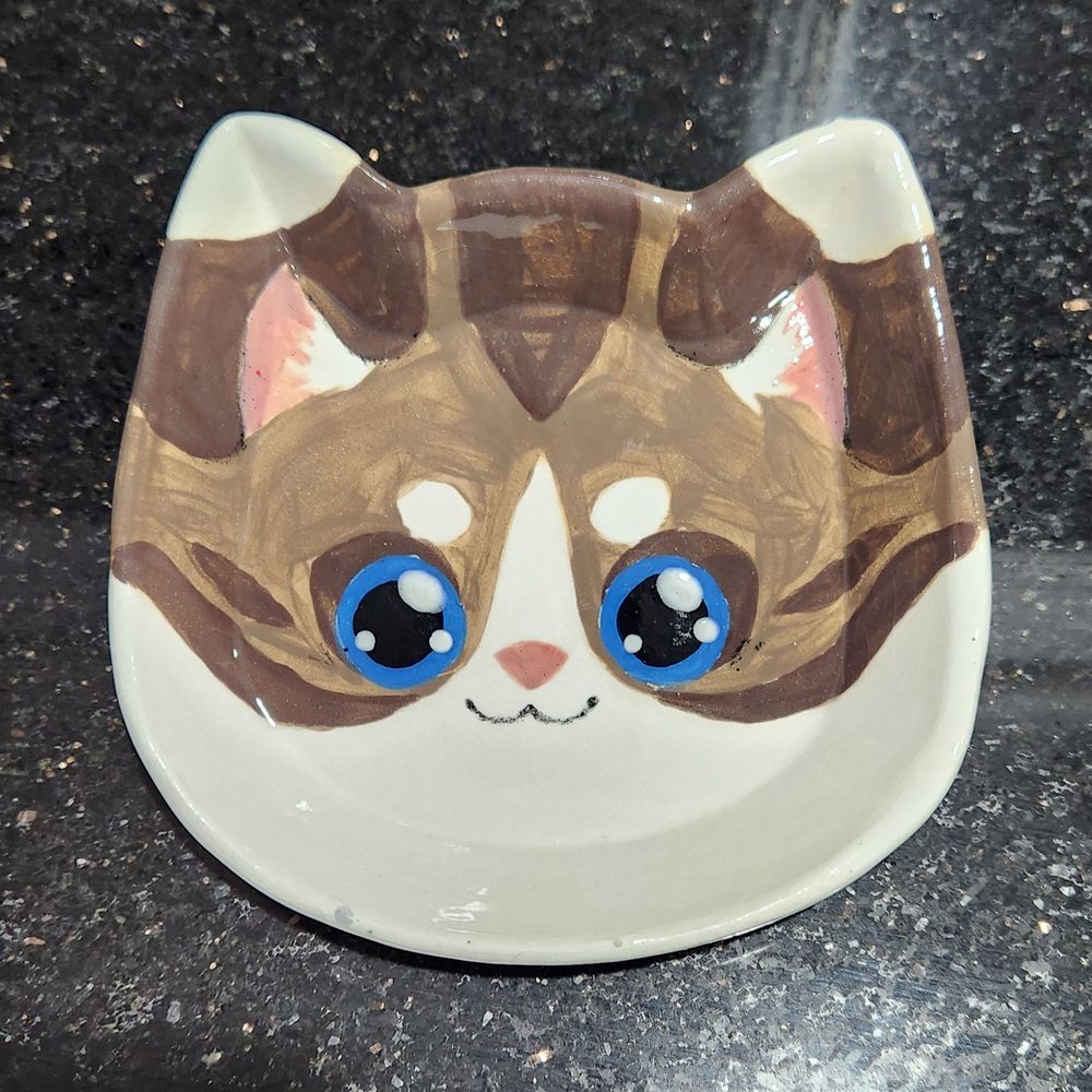 Handmade ceramic plate, shaped like a cat, painted to look like a fursona (@FrostedMonster)