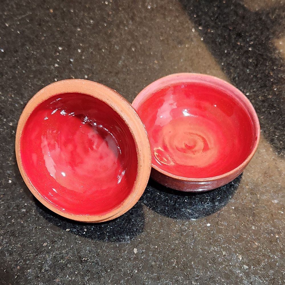 Inside of a terracotta pomegranate, thrown on a pottery wheel, with a bright red glaze