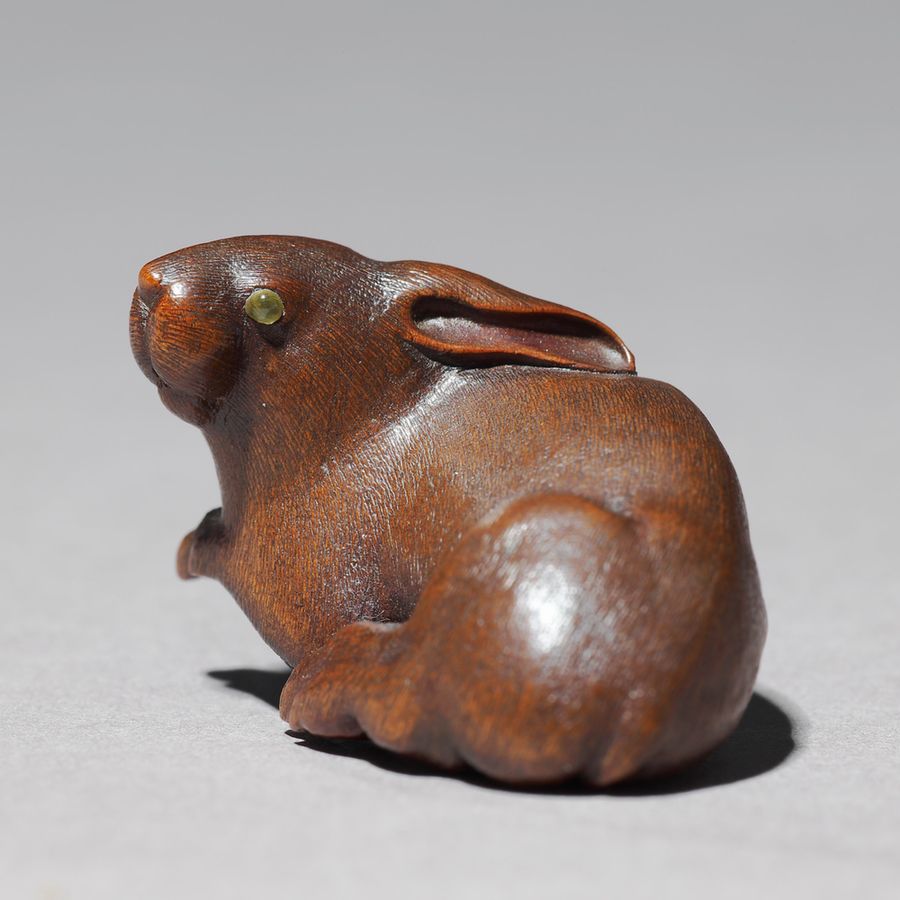 A small figure of a rabbit carved out of wood.
