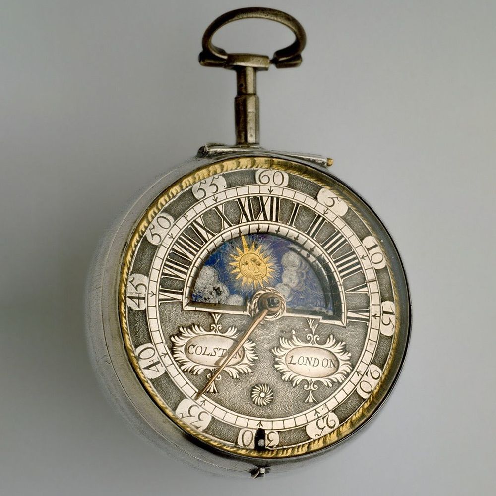 A round silver pocket watch with a revolving sun and moon display dial
