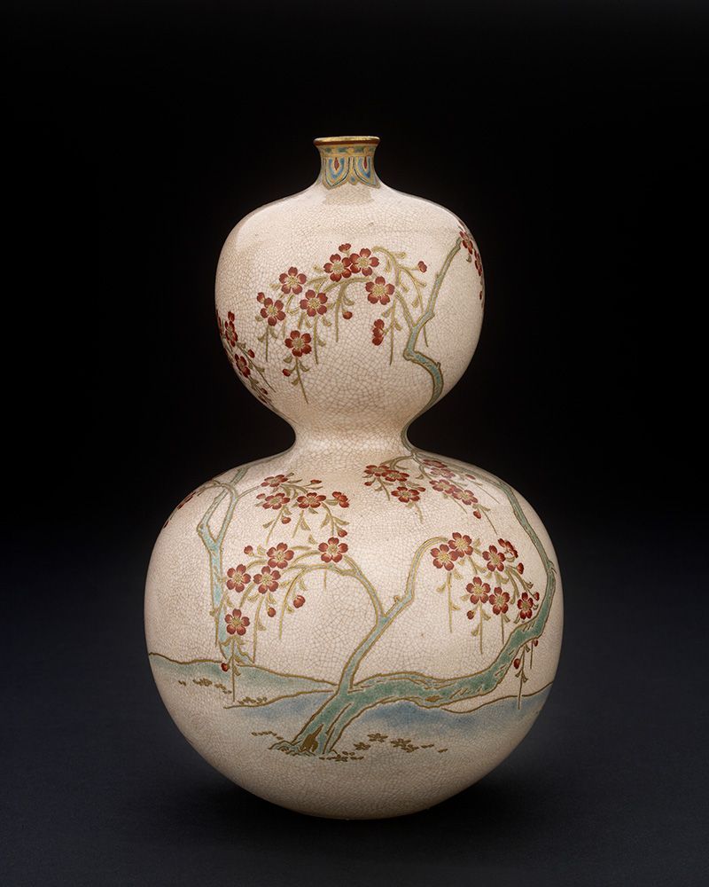 A photograph of the vase, a double-gourd form decorated with overglaze enamels. This photo shows cherry blossom sprawling over the vase