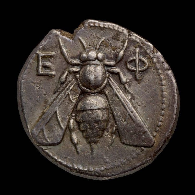 A silver coin depicting a bee.