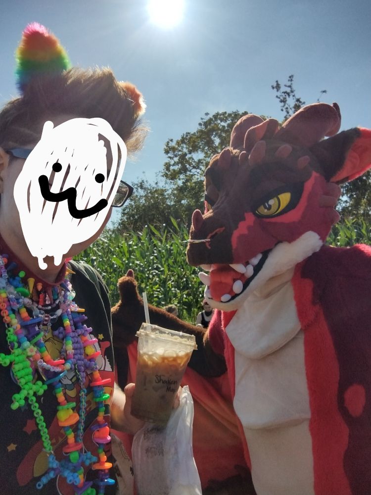 owlhops standing with a red dragon fursuiter