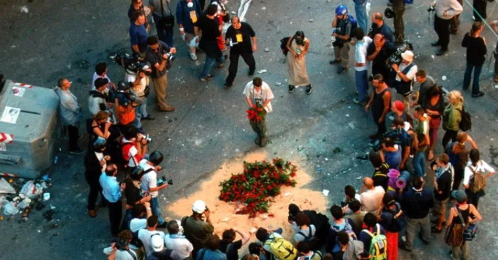 people in circle putting flowers on the street after carlo's death