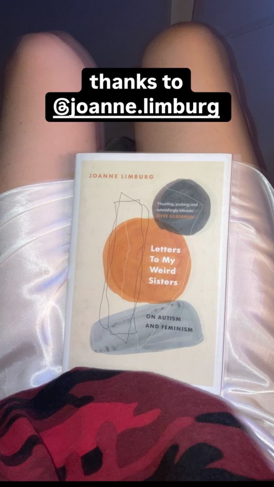 a blurry picture of the book by Joanne Limburg “Letters to my weird sisters. On autism and feminism” on my legs.