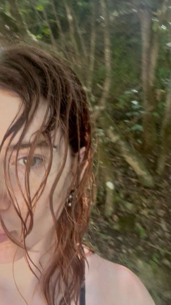 half face redhead woman in the middle of of a forest 