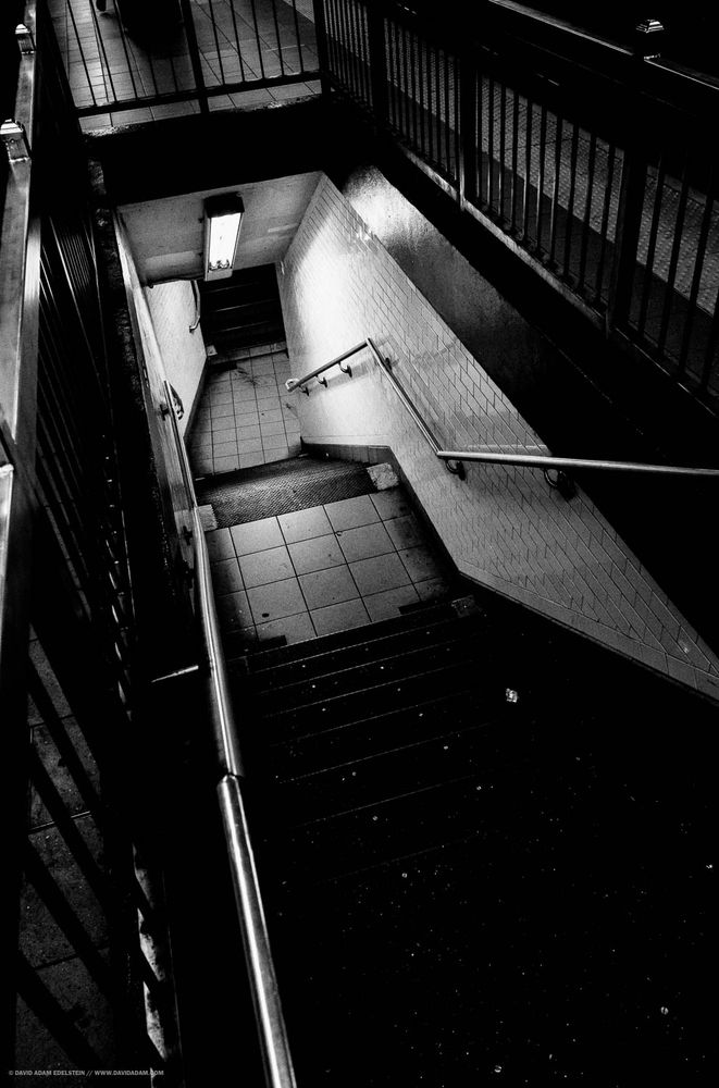 A stairway in a subway station, heading further underground. 