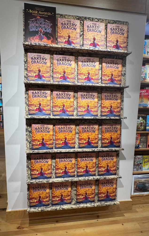 A big display in a Barnes and noble bookstore featuring the book “the bakery dragon” by Devin Elle kurtz
