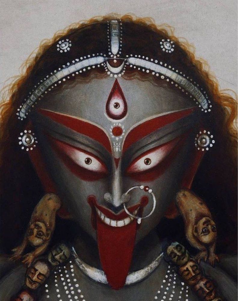The Hindu Goddess Ma Kali, fierce with her tongue out with red make up reflected on her grey eternal dark grey complexion 