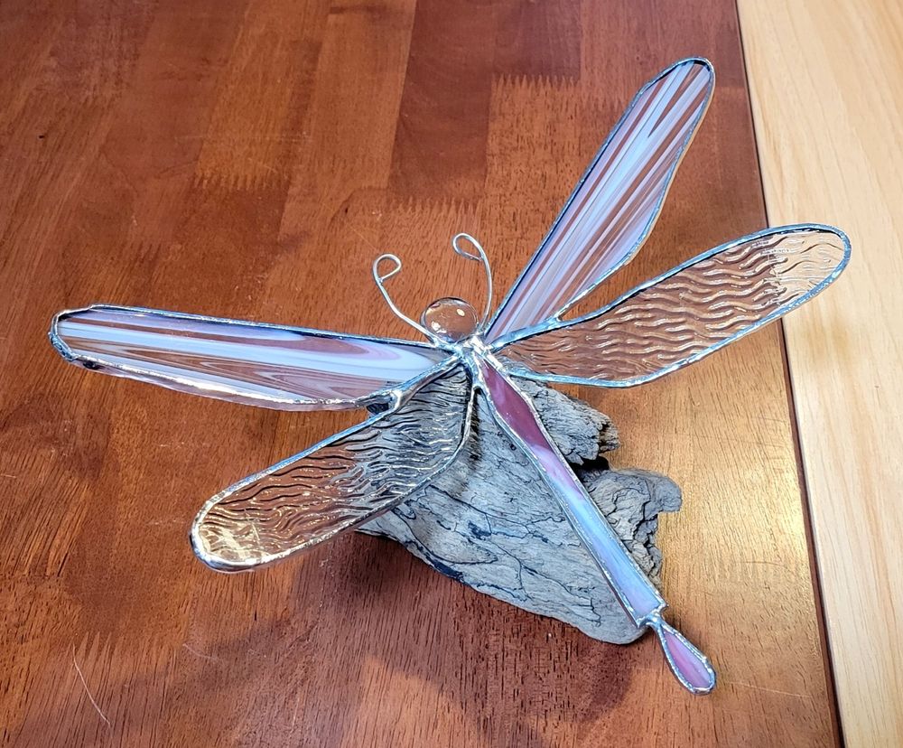 Stained glass dragonfly on a piece of driftwood