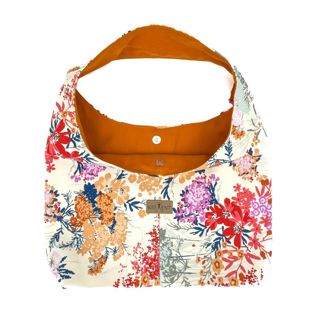 Kreallent | One Piece "Wilde Blumen"
Das Bild zeigt eine stilvolle Stofftasche mit floralem Design. Die Tasche ist in warmen Farben gehalten, darunter verschiedene Rot-, Orange- und Violetttöne, die sich lebhaft auf einem cremefarbenen Hintergrund abheben. Das Innenfutter der Tasche ist in einem satten Orange gehalten. Auf der Vorderseite ist ein kleines Etikett mit der Aufschrift "Kreallent" angebracht. Die Tasche wirkt modern und einladend, perfekt für den alltäglichen Gebrauch oder als modisches Accessoire.